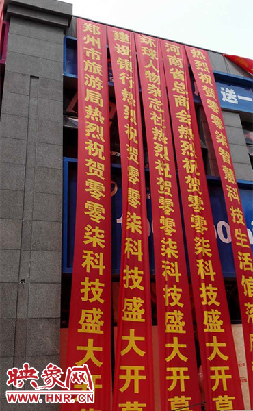 路邊一棟樓上懸掛著二三十條紅色條幅，全部是祝賀一家公司開業(yè)的。