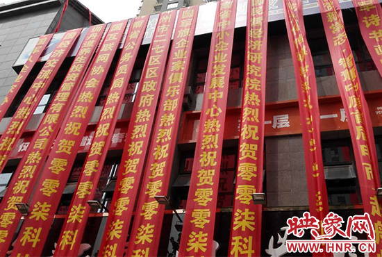 路邊一棟樓上懸掛著二三十條紅色條幅，全部是祝賀一家公司開業(yè)的。