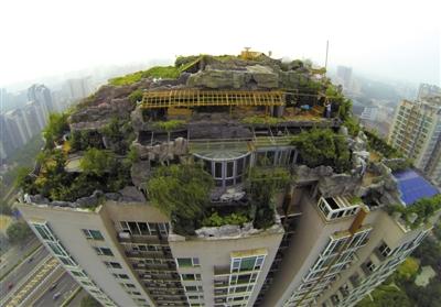 　　昨日，身穿橘黃色馬甲的工作人員在人濟(jì)山莊樓頂拆除違章建筑。新京報(bào)記者 吳江 攝