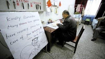 張大爺在門衛(wèi)室里工作，旁邊是紅爆網(wǎng)絡(luò)的溫馨提示牌記者