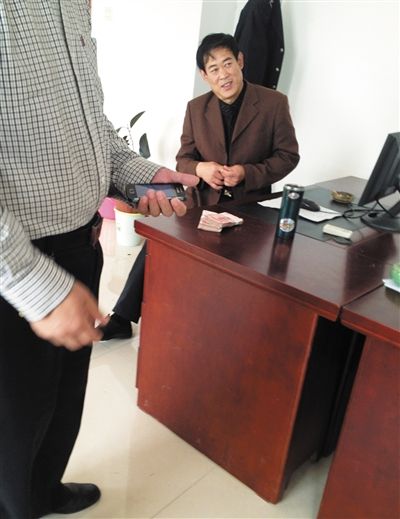 10月29日，獻(xiàn)縣國稅局稽查局辦公室內(nèi)，一名企業(yè)主交了兩萬元現(xiàn)金在桌上。新京報(bào)記者 孟祥超 攝