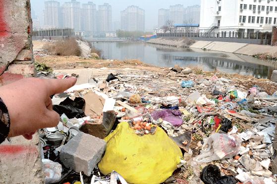金水河長(zhǎng)江路橋下河水發(fā)臭，水邊堆放眾多垃圾