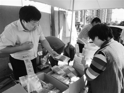 昨日，河南企業(yè)家劉春喜在京“練攤”，為顧客挑選綠豆。新京報記者 張玉學(xué) 攝
