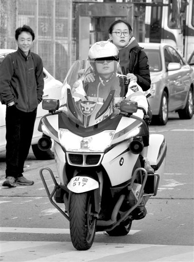 7日，首爾，警察將一名考生送抵考場。新華社發(fā)