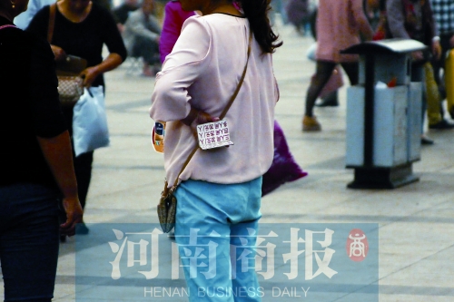 火車站廣場(chǎng)，一女子拿著寫有不同房型價(jià)位的卡片在拉客，不少市民抱怨，受過(guò)此類“騷擾”