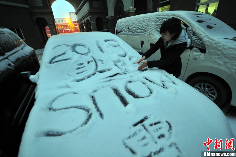 11月18日，行人在車輛的積雪上涂鴉。