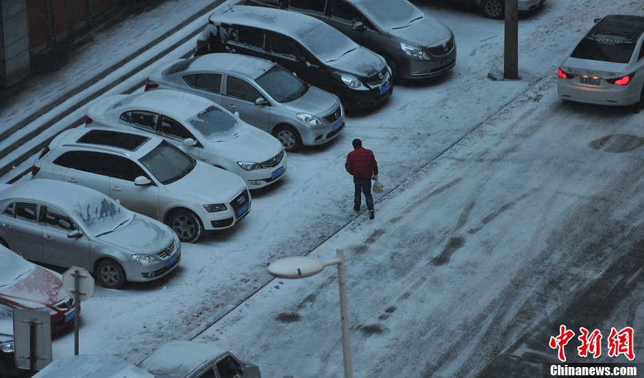 11月18日，行人在沈陽街頭的積雪中穿行。