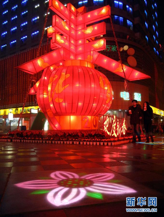 　1月30日晚，市民從蘇州市石路銀河廣場上大型“春”字彩燈景觀旁經(jīng)過。