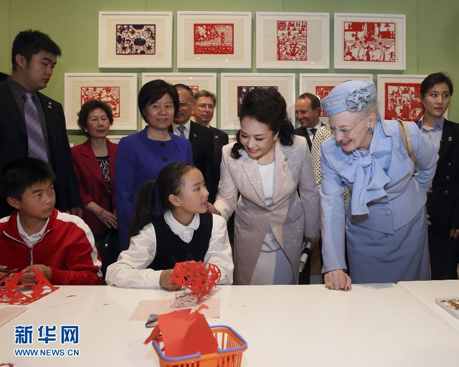 這是彭麗媛和瑪格麗特二世與根據(jù)安徒生童話中人物和情節(jié)制作剪紙的孩子交談。