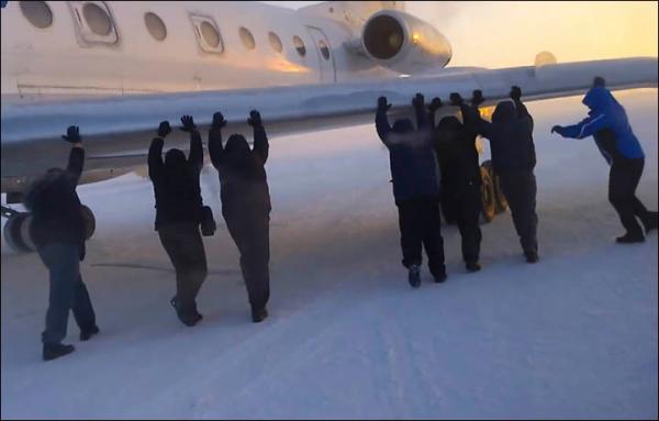 伊加爾市一架客機起飛前被凍在了跑道上。飛機上的乘客不得不下來推飛機。