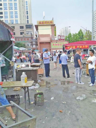 昨天，執(zhí)法人員在京廣路長(zhǎng)江路口整治“僵尸圍擋”及圍擋內(nèi)的攤販。