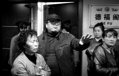 昨日，在河北香河天下第一城，相關(guān)負(fù)責(zé)人（左二）走出會議室與參加演出的老人們溝通。