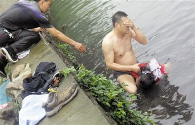 網(wǎng)友貼出民警張光聰一出河水就睜不開眼，用手抹去臉上臟水的照片。