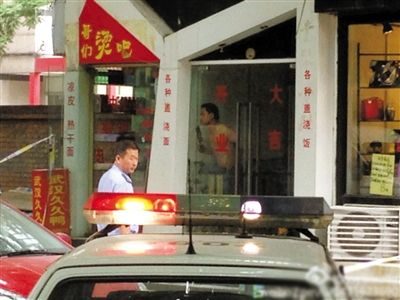 闖入面館的持刀男子與趕來的民警隔著玻璃門對峙，后店內(nèi)一名女童被其劫持。網(wǎng)友供圖