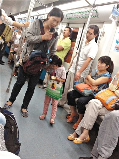 6月27日，舒馨帶一女孩在地鐵十號線行乞。她因被疑帶多個不同小孩乞討被警方搜尋。新京報(bào)記者 申志民 攝