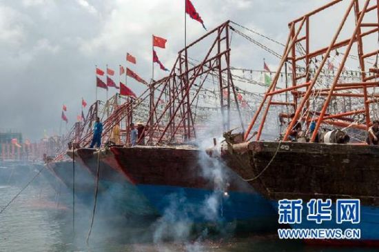 2013年8月1日 南海開漁日 臨高迎新港 8月1日，海南省臨高縣漁民在船上鳴放鞭炮慶祝武蓮港開港。