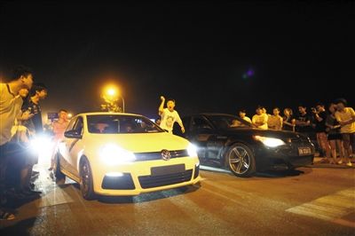 8月24日晚，東壩中街飆車現(xiàn)場(chǎng)，兩輛車并排等待出發(fā)指令，旁邊許多愛(ài)好者前來(lái)觀看比賽。新京報(bào)記者