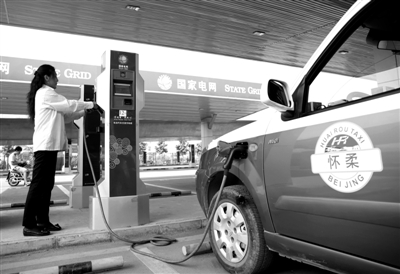9月11日，懷柔區(qū)，電動(dòng)出租車司機(jī)正在為車輛充電。