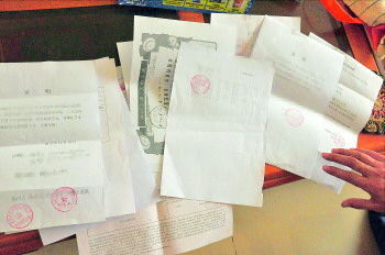 60歲的市民仇先生為了辦理公證所需的這些證明材料,半個月時間里跑了30多趟腿。記者　李萌博　攝