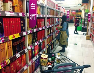 顧客在商場(chǎng)的高檔白酒貨架前駐足挑選。春節(jié)臨近，受“禁令”影響，以高檔白酒為代表的節(jié)日禮品市場(chǎng)面臨考驗(yàn)。記者 王遠(yuǎn)征 攝