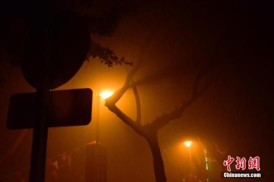 1月31日凌晨，市民行走在煙霧繚繞的南京街頭。當(dāng)天是農(nóng)歷馬年正月初一，南京有限開禁燃放煙花爆竹正逢下霧天，空氣的不流通致使煙花爆竹燃燒后產(chǎn)生的顆粒物不能及時(shí)散開，造成整座城市煙霧繚繞。據(jù)當(dāng)?shù)丨h(huán)保部門發(fā)布的信息顯示，空氣質(zhì)量屬重度污染。中新社發(fā) 泱波 攝
