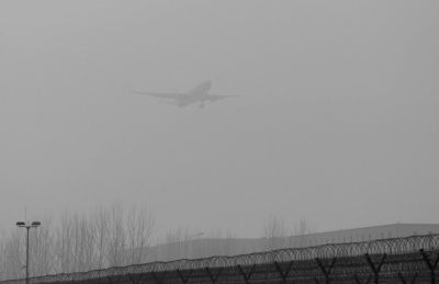在首都機(jī)場(chǎng)，飛機(jī)在霧霾中降落。
