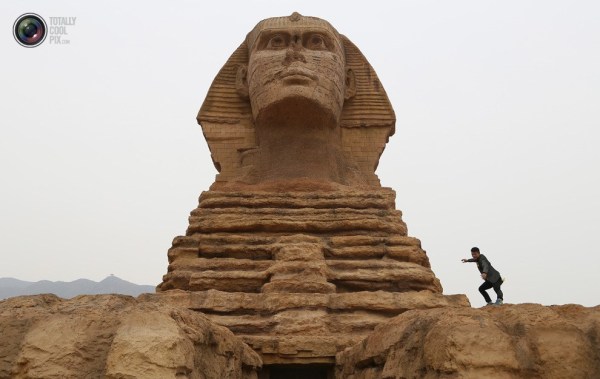 石家莊郊外，一名男子與山寨版獅身人面像合影留念。