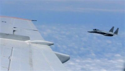 國防部網(wǎng)站12日公布的視頻截圖,日本F-15軍機從中國圖-154機頭方向危險切入,兩者最近距離約30米左右。
