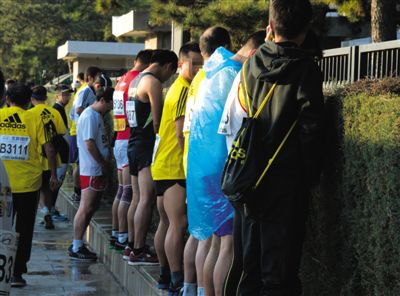 2013年10月20日，北京馬拉松比賽，由于廁位有限，一些選手在綠化帶“就地解決”。圖/IC