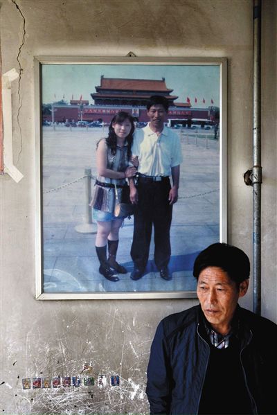 11月14日，承德市平泉縣，潘小梅父母的家，潘小梅父親靠在墻上，身后掛著數(shù)年前他和潘小梅在北京的合影照片。新京報記者