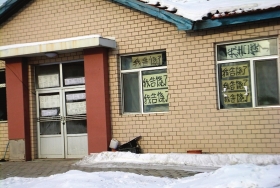 伊春市帶嶺區(qū)一排破舊的平房，房間窗戶上貼滿了“我告饒了”的字樣。