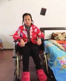 陳慶霞坐在輪椅上。她現(xiàn)在下身癱瘓，疾病纏身，生活不能自理。