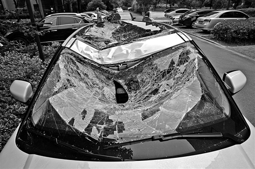 越野車車蓋以及前擋風(fēng)玻璃被砸得凹陷進(jìn)去。見習(xí)記者姚卡/攝