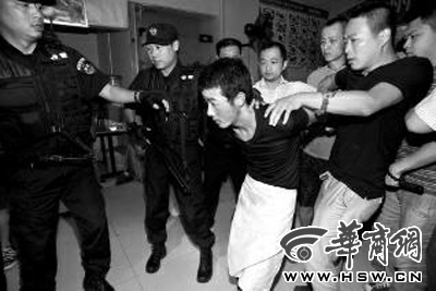 犯罪嫌疑人韓牙某圍著圍裙在廚房?jī)?nèi)拉面，被民警抓獲 本報(bào)記者 鄧小衛(wèi) 攝