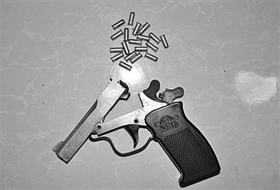 警方從搶劫嫌疑人處起獲的贓款和發(fā)令槍、子彈。警方供圖