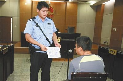 昨日庭審中，法警向趙某出示其扎完車胎后所留辱罵公司的紙條。通訊員 李秀文 攝