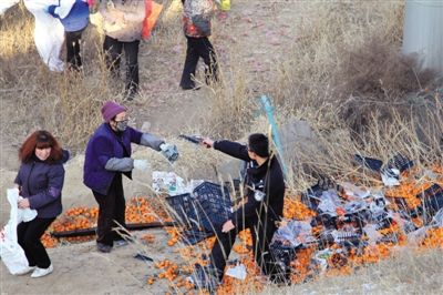 1月4日，連霍高速蘭州市榆中縣和平鎮(zhèn)段，一名警察舉著槍驅(qū)散哄搶橘子的村民。圖/CFP