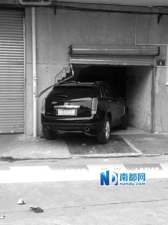 　昨日，凱迪拉克撞人后停在一倉(cāng)庫(kù)門口，車后有一攤血跡。 南都記者陳杰生攝