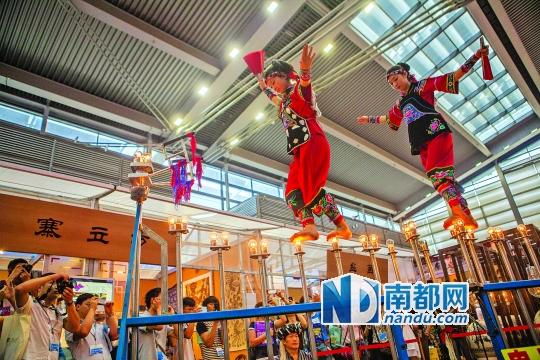 2號(hào)展館，苗族姑娘表演踩燈泡絕技《電光玫瑰》，赤腳踩上40瓦的燈泡并做出高難度動(dòng)作。 南都記者 霍健斌 攝