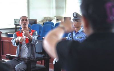 張志國(guó)在法庭上用手語(yǔ)回答提問(wèn)。記者 蒲東峰攝