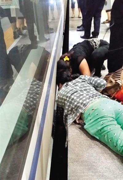 一女子趴在站臺(tái)上，救跌入列車和站臺(tái)間隙的男童。網(wǎng)友璀璨的星月夜 攝