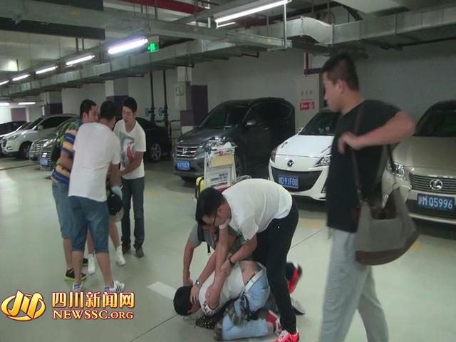 辦案人員在機(jī)場(chǎng)停車(chē)場(chǎng)抓獲胡某及其女友（警方視頻截圖）。