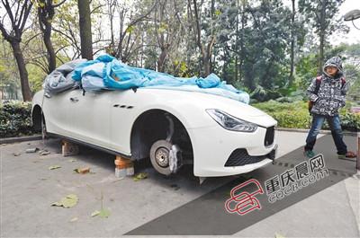 昨日，停放在重慶大學(xué)B區(qū)的一輛瑪莎拉蒂豪車被架在幾塊磚頭上，車輪不翼而飛。 重慶晨報(bào)記者 胡杰 攝