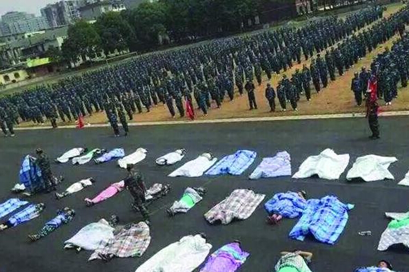 20多名女生躺在瀝青跑道上，身上嚴(yán)嚴(yán)實(shí)實(shí)地裹著棉被，接受太陽(yáng)的照曬。