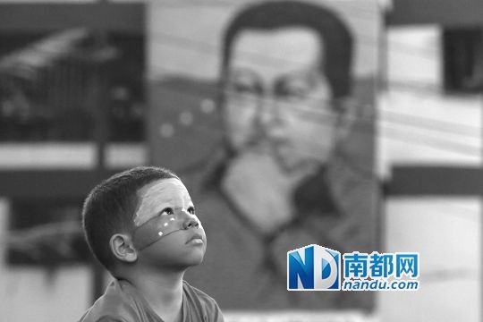 3月5日，一名委內(nèi)瑞拉兒童仰望天空，他身后是查韋斯的陵墓。