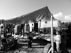黎巴嫩一敘利亞難民營(yíng)，難民支起攤鋪賣衣服掙錢。