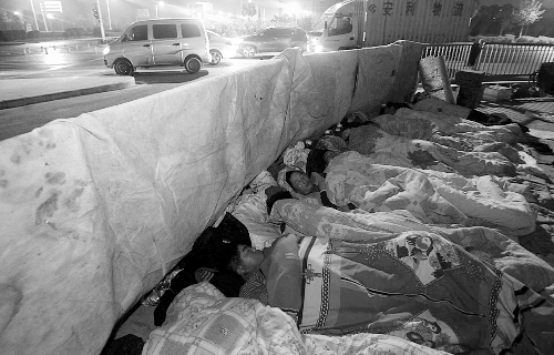在寒冷的冬夜，為了能省點(diǎn)錢，方便接活，民工們?nèi)运跇蛳隆? complete=