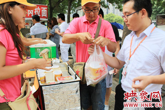 圖為徐貴雨和一名勤工助學(xué)的學(xué)生在街頭義賣快餐。