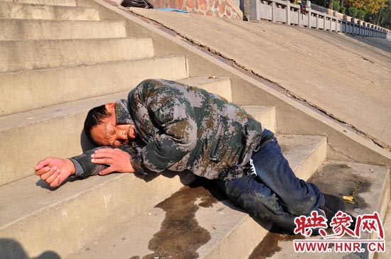 這名男子的衣服以及褲子全濕透了，水從衣褲里流出來，嘴里散發(fā)著濃烈的酒氣。