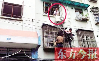 施救現(xiàn)場(chǎng)，劉鵬（圈內(nèi)）先用繩子捆住老太確保安全 勞動(dòng)報(bào)記者 郭娜 供圖